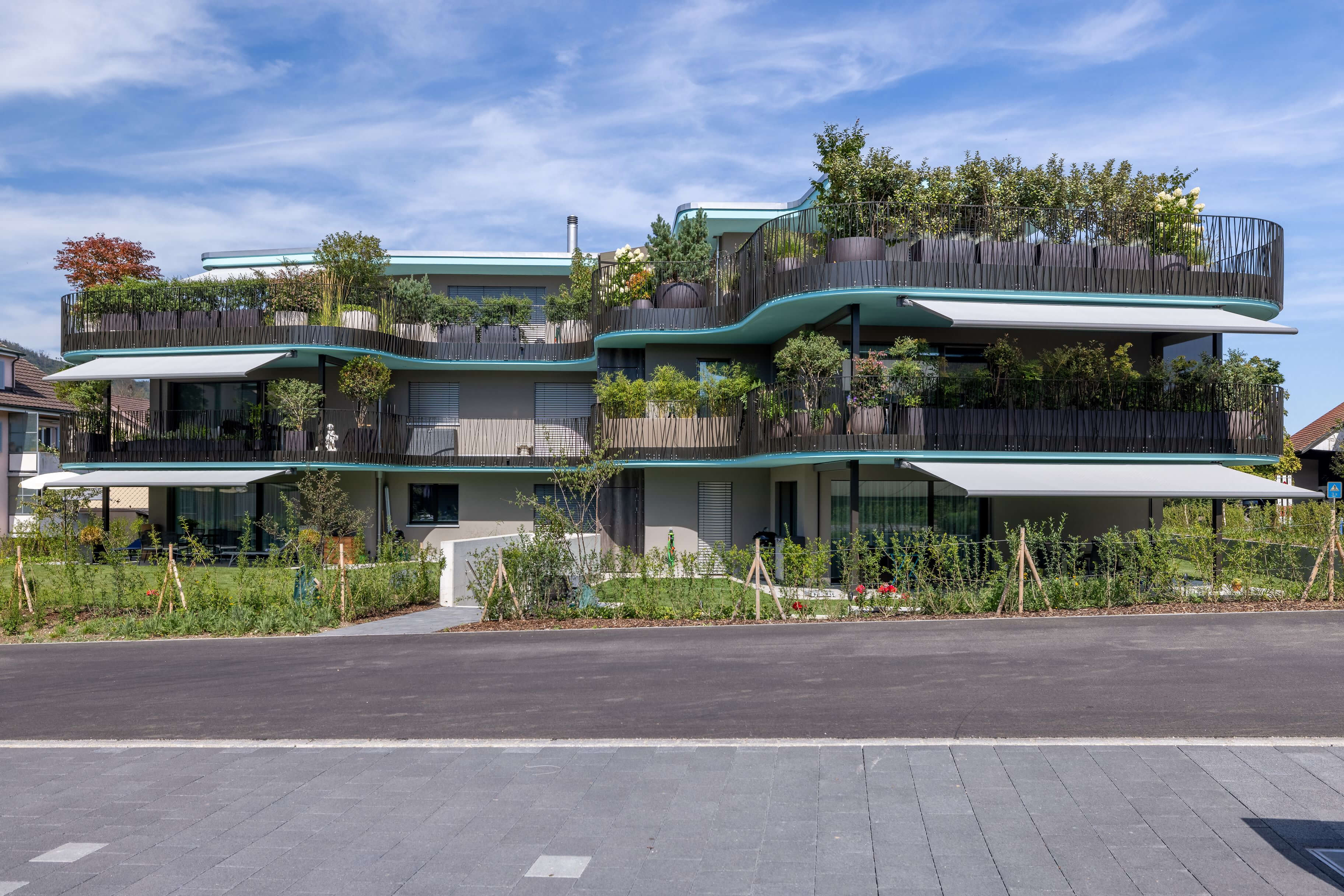 Zeitgemäße Wohnarchitektur mit Balkonen und viel Grün